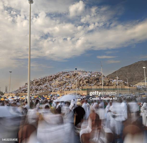 pilgrims gather near jabal ar rahma or mountain of mercy near arafat or mina, where pilgrims stay during hajj or pilgrimage near khaana kaaba in holy mosque of al haram | motion of people wearing ihram - mina stock-fotos und bilder