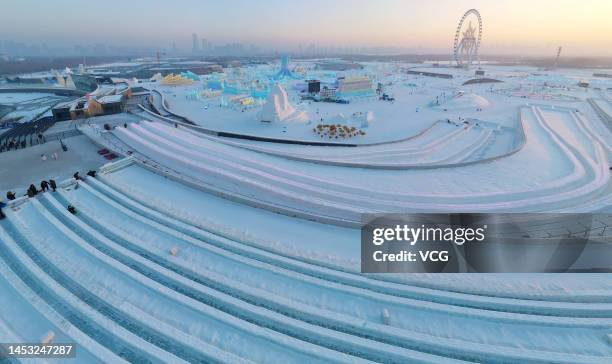 Aerial view of a tourist sliding down an ice slope at the 24th Harbin Ice and Snow World on December 29, 2022 in Harbin, Heilongjiang Province of...