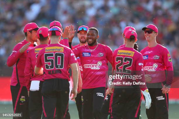 Chris Jordan of the Sixers celebrates the dismissal of Martin Guptill of the Renegades with team mates during the Men's Big Bash League match between...