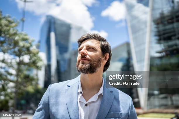 uomo d'affari che contempla in un distretto finanziario - tuxedo foto e immagini stock