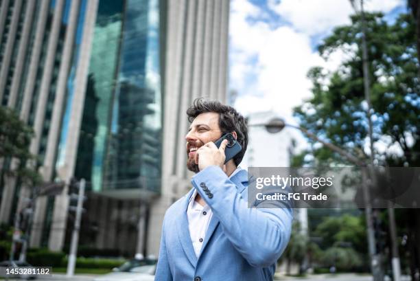 uomo d'affari che parla al telefono in un distretto finanziario - cfo foto e immagini stock