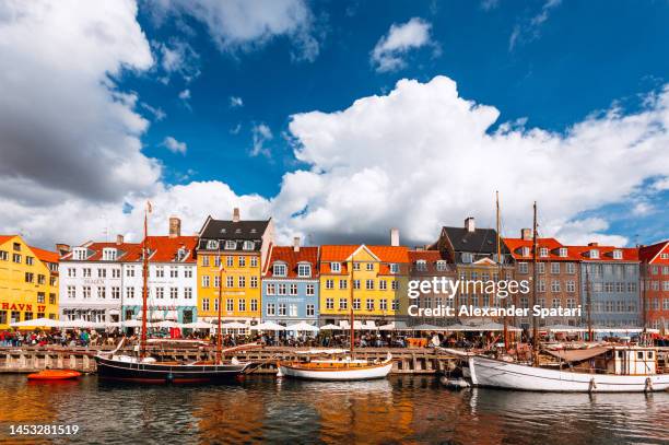 multicolored vibrant houses along nyhavn harbor on a sunny day, copenhagen, denmark - kopenhagen stock-fotos und bilder