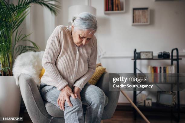 la anciana tiene dolor en la rodilla - arrodillarse fotografías e imágenes de stock
