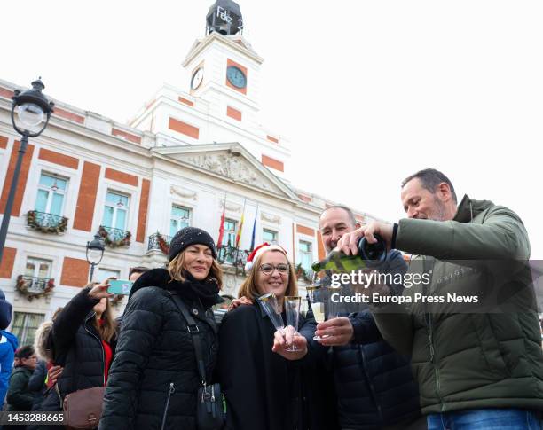 Several people celebrate with drink during the Preuvas at Puerta del Sol on December 30, 2022 in Madrid, Spain. The Preuvas is a rehearsal for the 12...