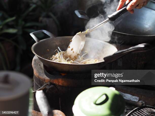 woman cooking on a pan, charcoal stove - salteado imagens e fotografias de stock