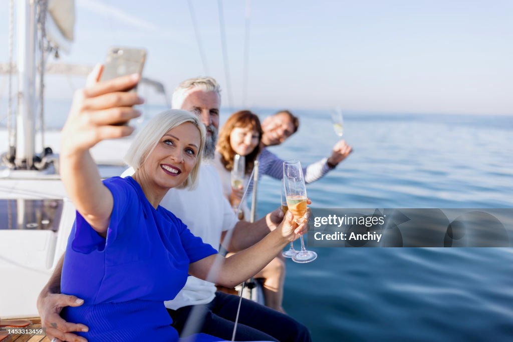 Happy friends on a yacht drinking champagne