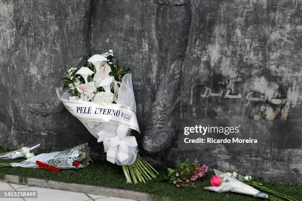 Flowers rest next to a statue of Pele at Vila Belmiro Stadium on December 30, 2022 in Santos, Brazil. Brazilian football icon Edson Arantes do...