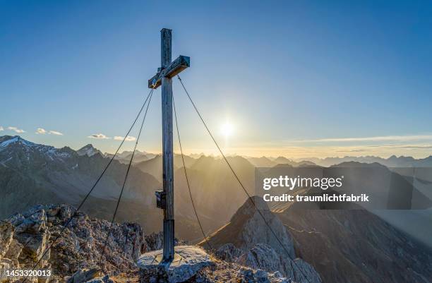 summit cross at sunset - gipfelkreuz stock-fotos und bilder