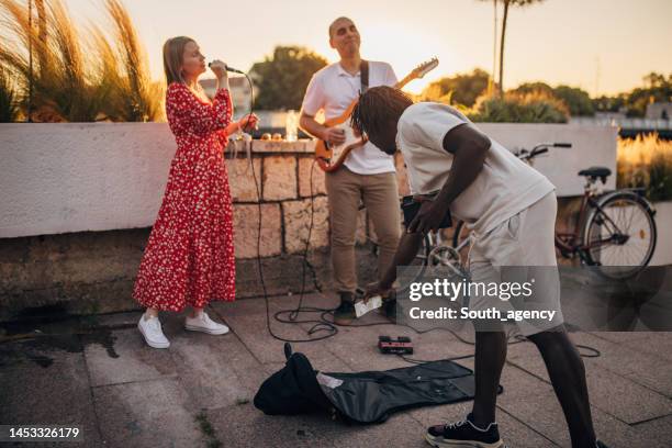 mann gibt straßenmusikern geld - straßenmaler stock-fotos und bilder