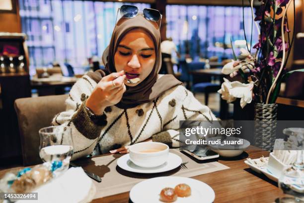 jeune adulte mangeant de la soupe au restaurant - iftar photos et images de collection