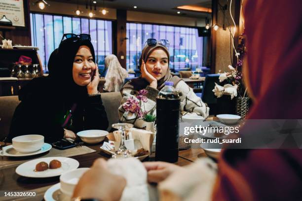 asian women enjoying dinner in restaurant - iftar stock pictures, royalty-free photos & images