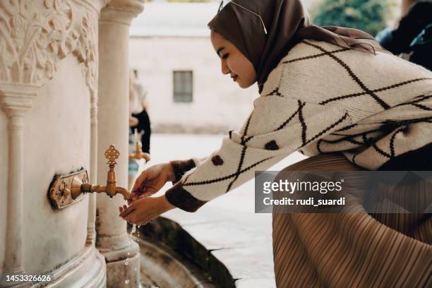 muslim woman taking ablution for prayer - mecca stock pictures, royalty-free photos & images