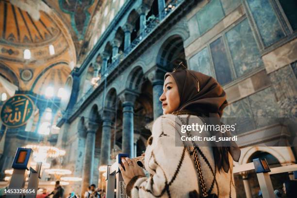 junge muslimische frau in der hagia sophia - blue mosque stock-fotos und bilder