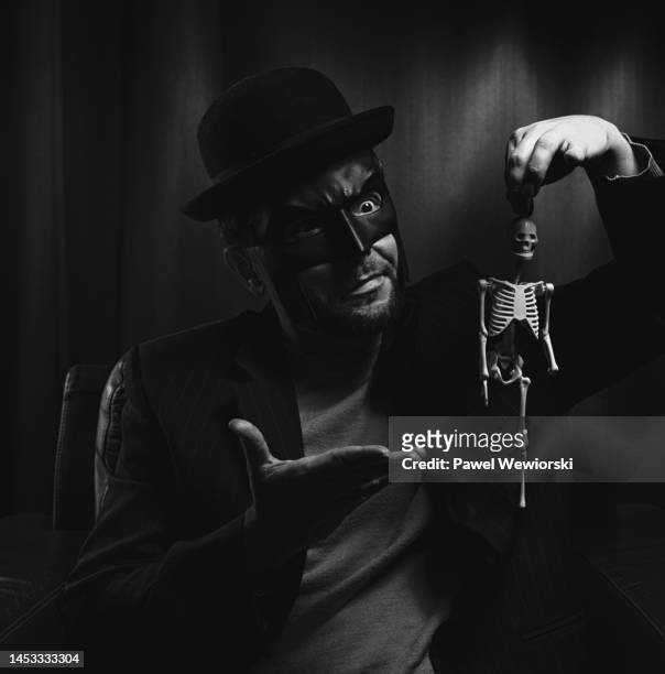 man holding toy skeleton - illuminati stockfoto's en -beelden