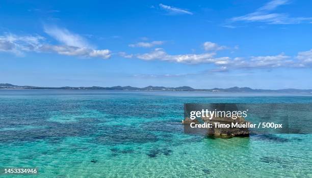 scenic view of sea against sky,okinawa,okinawa prefecture,japan - okinawa blue sky beach landscape stockfoto's en -beelden