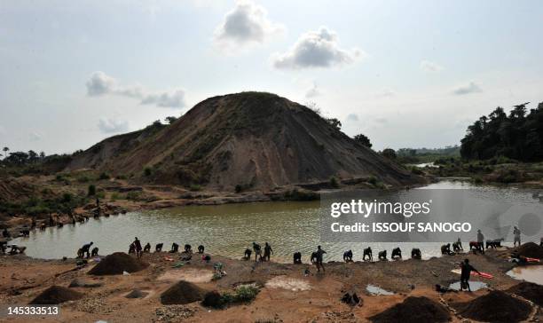 Diamond prospectors filter earth from a river on April 28 in Koidu, the capital of the diamond-rich Kono district, in eastern Sierra Leone, some 250...