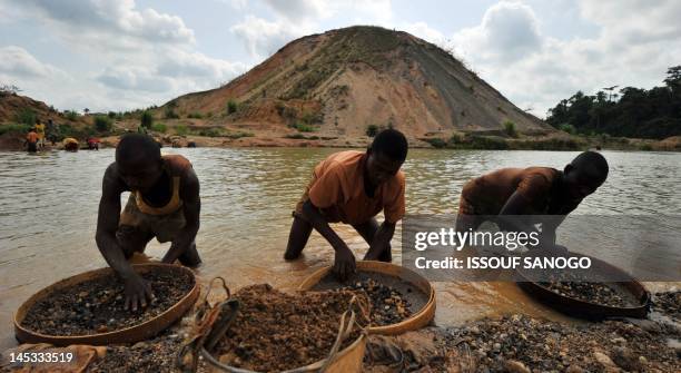 Diamond prospectors filter earth from a river on April 28 in Koidu, the capital of the diamond-rich Kono district, in eastern Sierra Leone, some 250...