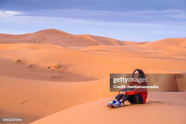 woman traveler traveling alone watches the sunset from the desert dunes. traveling alone is a great opportunity to improve personal self-knowledge. - sahara　sunrise stock pictures, royalty-free photos & images