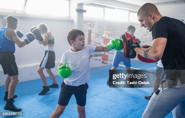 group of kids practicing with instructor boxing at gym - boxing training stock pictures, royalty-free photos & images