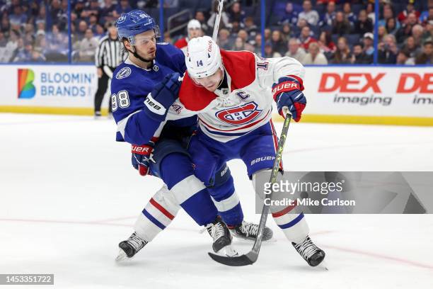 Mikhail Sergachev of the Tampa Bay Lightning and Nick Suzuki of the Montreal Canadiens collide during the game at the Amalie Arena on December 28,...