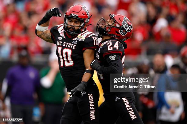 Tanner Ingle of the North Carolina State Wolfpack reacts with teammate Derrek Pitts Jr. #24 following a sack during the second half of the Duke's...