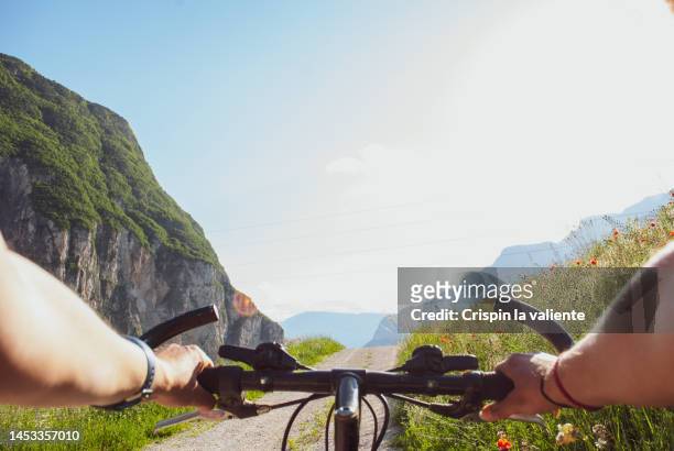 point of view of woman riding a bike in the alps - manillar fotografías e imágenes de stock