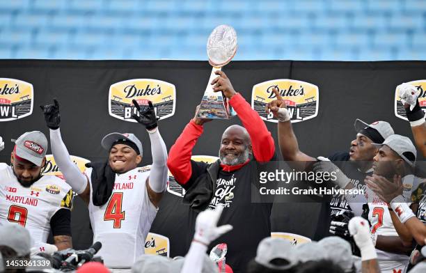 Head coach Mike Locksley of the Maryland Terrapins and his players celebrate with the trophy after defeating the North Carolina State Wolfpack in the...