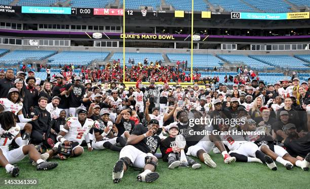 Maryland Terrapins players take a team photo with the trophy after defeating the North Carolina State Wolfpack in the Duke's Mayo Bowl at Bank of...