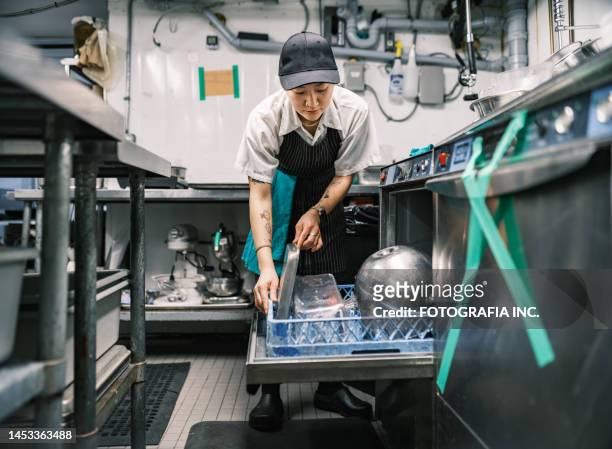 junge koreanische köchin in der restaurantküche - dishwasher stock-fotos und bilder