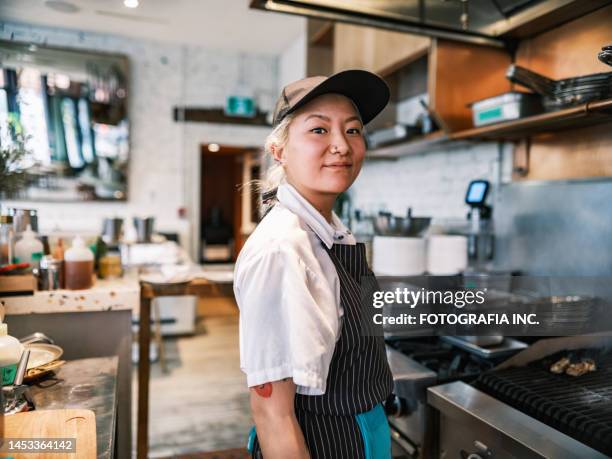 young korean female chef working in restaurant bar kitchen - kockar bildbanksfoton och bilder