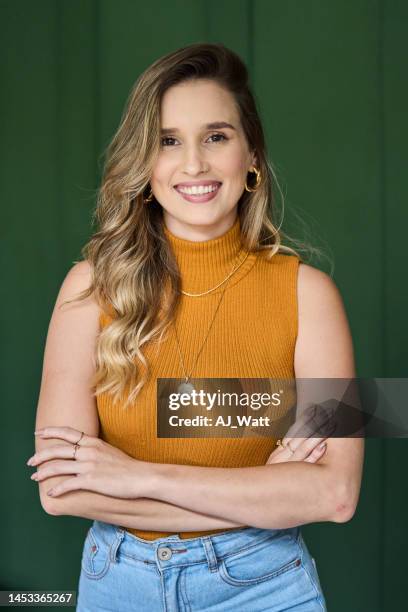 young female architect smiling while standing with her arms crossed - colour background and young adult stock pictures, royalty-free photos & images