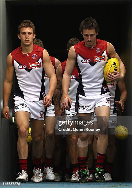 Jack Trengove and Jack Grimes of the Demons lead their team out onto the field during the round nine AFL match between the Carlton Blues and the...