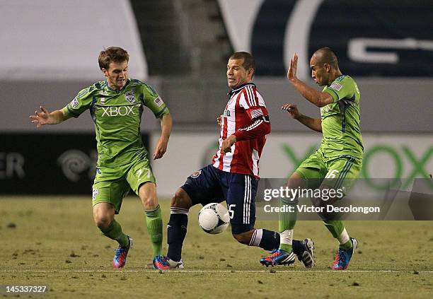 Alex Caskey and David Estrada of the Seattle Sounders close in defensively on Alejandro Moreno of Chivas USA in the second half of the MLS match at...