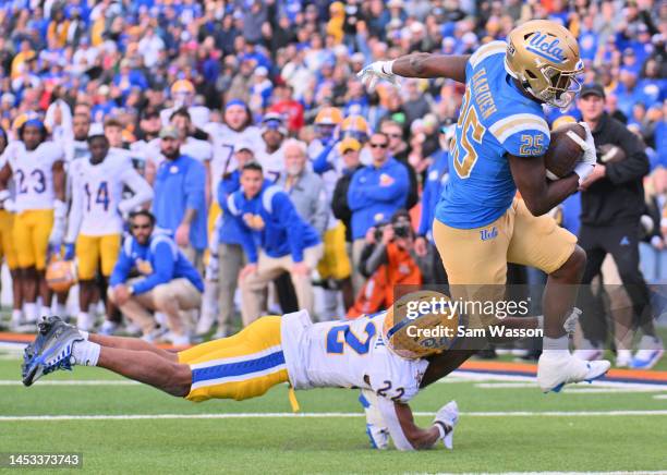 Running back T.J. Harden of the UCLA Bruins runs for a touchdown against defensive back Phillip O'Brien Jr. #22 of the Pittsburgh Panthers during the...