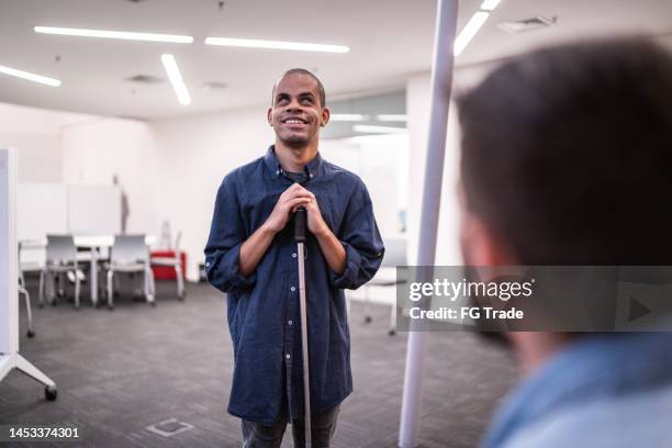 homem adulto médio com deficiência visual dando palestra para estudantes da universidade - deficiência visual - fotografias e filmes do acervo