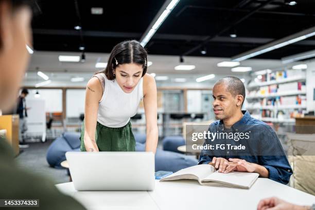 young woman using a laptop while talk whit friend visually impaired at university - accessibility blind stock pictures, royalty-free photos & images