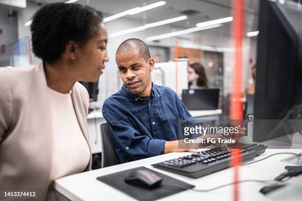 mature woman support university student (or worker) with visually impaired to use computer at library - disabled accessibility stock pictures, royalty-free photos & images