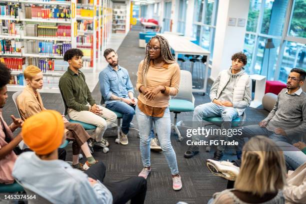 young university student woman lecturing to students at university - onderwijsinstituten en organisaties stockfoto's en -beelden