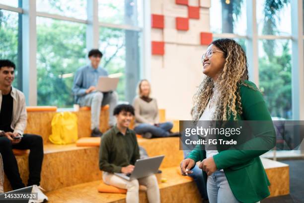 university student woman giving lecture to students at the university auditorium - university professor stock pictures, royalty-free photos & images