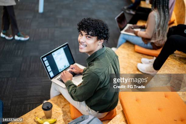 portrait of a university student at university auditorium - working on laptop in train top view stock pictures, royalty-free photos & images