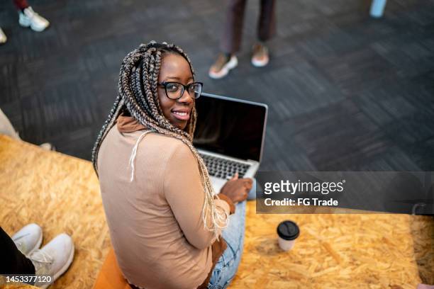 porträt einer studentin, die einen laptop in der aula der universität benutzt - brazil training and press conference stock-fotos und bilder