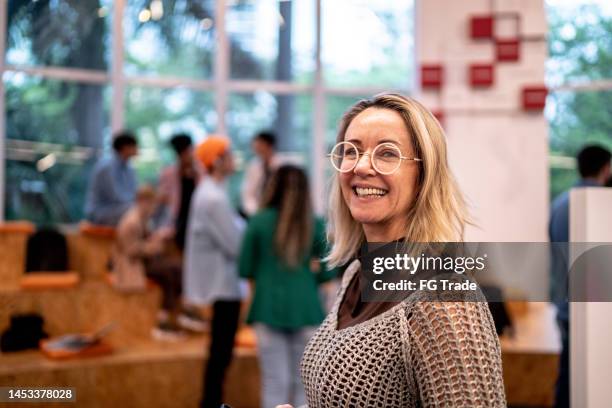 portrait of a mature woman at university - portrait of teacher and student stockfoto's en -beelden