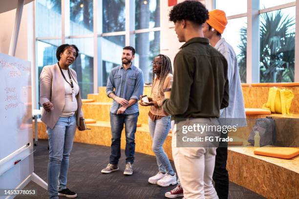 mature teacher explaining lesson to university students at university - brazil training and press conference stock pictures, royalty-free photos & images