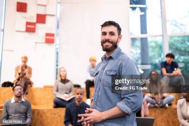 portrait of a mid adult man at auditorium - man press conference stock pictures, royalty-free photos & images