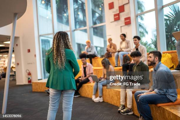 young student woman giving lecture to students at the university - university student support stock pictures, royalty-free photos & images