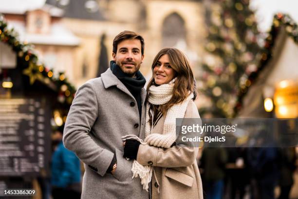 feliz pareja joven disfrutando de un día de navidad juntos en la ciudad. - anorak fotografías e imágenes de stock