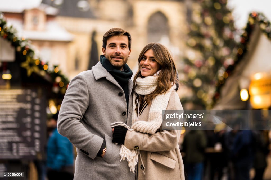 街で一緒にクリスマスの日を楽しむ幸せな若い夫婦。