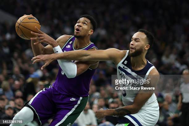 Giannis Antetokounmpo of the Milwaukee Bucks is fouled by Kyle Anderson of the Minnesota Timberwolves during the first half of a game at Fiserv Forum...