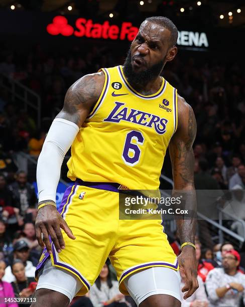LeBron James of the Los Angeles Lakers reacts after dunking against Onyeka Okongwu of the Atlanta Hawks during the fourth quarter at State Farm Arena...