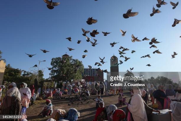 Flock of pigeons flies over the courtyard of St. Mary's Orthodox Church as parishioners of the Orthodox Faith gather to observe the monthly feast...